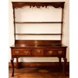 A George III oak dresser, circa 1760, moulded cornice open plate rack, on a rectangular moulded edge