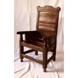 A 19th Century grain tarnished pine wainscot chair, circa and carved 1800, in a 17th century manner,