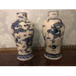A pair of 19th Century Chinese blue and white baluster vases, decorated with dragons, blue four