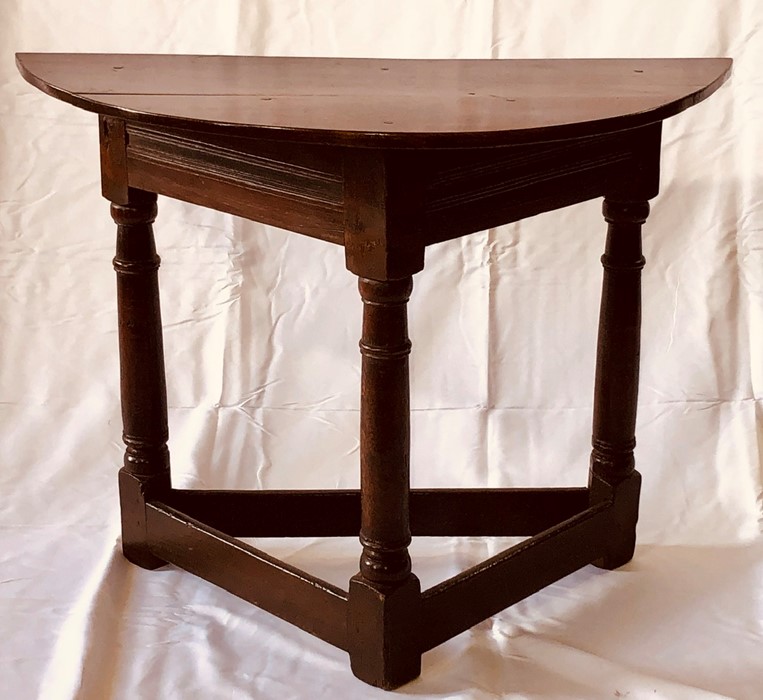 A mid 17th Century period credence table, demi-lune top on a tri-form frame, raised on turned