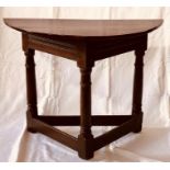A mid 17th Century period credence table, demi-lune top on a tri-form frame, raised on turned