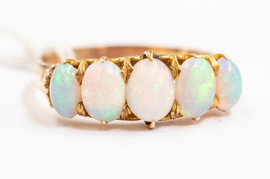 An opal and 14ct gold ring, set with five graduated oval opals, claw set,  size V, unmarked, total