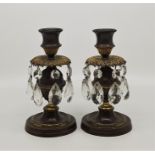 A pair of 19th Regency bronze parcel gilt candlesticks with cut glass drop lustres, height 15.4cm,