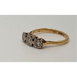 An 18ct. gold three stone diamond ring, illusion set three graduated round cut diamonds, assayed