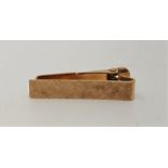 A 14ct. gold tie clip, with textured finish and sprung hinge, length 32mm. (3.9g)