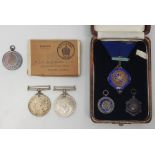 A collection of four various silver and silver and enamel medals, together with 1939-1945 Defence