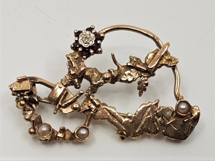 "Desert Sun", a 9ct. gold, diamond, pearl and garnet brooch by Sheana M.Stephen, with original