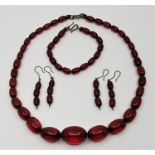A vintage string of graduated simulated oval cherry amber beads, c.1930's, necklace length 54cm ,