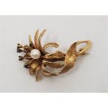 A 14ct. gold, sapphire and cultured pearl set "flower" brooch, with textured petals and leaves,