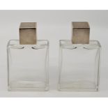 A pair of rectangular glass scent bottles with engine turned screw-on silver tops, by George