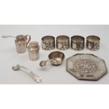 A white metal cruet and napkin ring set, to include: octagonal salt, salt spoon and tray. pepper and