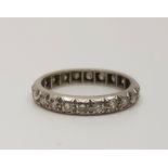 A precious white metal diamond eternity ring,  set numerous round cut diamonds (total diamond weight