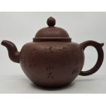A Chinese Yixing tea pot, with calligraphy to the main body and circular seal to underside.