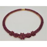 A 14 gold and ruby choker necklace, formed from a series of links each set pair of oval cut rubies