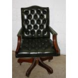 A green button hide upholstered swivel office armchair
