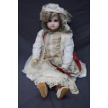 An early 20th century Jumeau porcelain headed doll, numbered 13. Fixed eyes and closed mouth, pierce