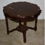 An Edwardian oak occasional table, the circular serpentine top on ring turned and block supports uni