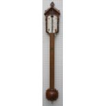 A Victorian oak Gothic carved mercurial stick barometer thermometer with hemisphere reservoir cover.
