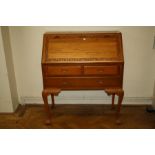 A mid 20th century Oriental teak bureau, the florally carved banded fall enclosing fitted interior o