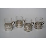 A set of four silver framed early 20th century Turkish coffee glasses. The frames with scroll handle