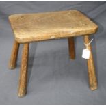 A rustic elm farm stool with hewn legs