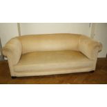 An early 20th century Chesterfield three person settee, later upholstered, on bun feet and castors,