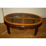A figured veneer coffee table, oval top with quadrant glass inserts on Chinese type legs. 44 x 122 x