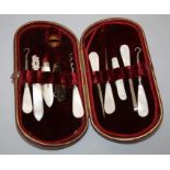 An Edwardian manicure/vanity set, red plush lined case with mother of pearl appointments