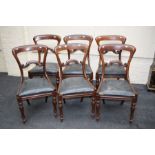 A set of six early Victorian figural mahogany dining chairs, with shaped cresting rails, drop in sea