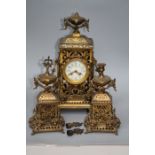 A late 19th/early 20th gilt metal cased three piece clock garniture. The eight day clock with swag