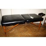 A large leatherette upholstered masseuses treatment table, electrically heated. 214cm long Formally