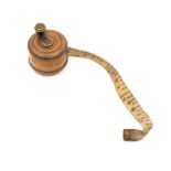 A miniature treen tape measure, circa 1900, diameter 2.5cm