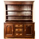 A George II period oak dresser, circa 1750, moulded pediment above three shelves flanked with