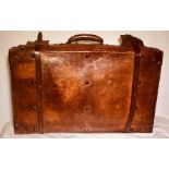 A mid 20th Century leather brass stud mounted travel suitcase, the hinge leather stitched, mounted