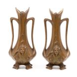 A pair of bronzed Art Nouveau twin handled vases, decorated with maidens' faces, tendril handles,