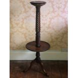 A George III style mahogany torchiere stand, circular moulded edge top, above a twisted column on