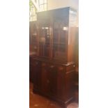 A Georgian revival mahogany bookcase on sideboard, dental pediment above two panel glazed doors,