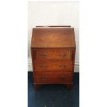 A 20th Century crossbanded mahogany fall front bureau, above three graduate drawers, raised on