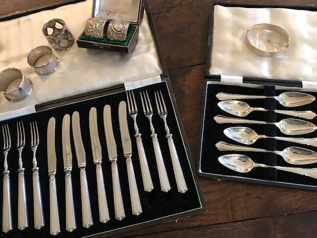 Two cases of hallmarked silver flatware, (a dessert set and grapefruit set), five silver napkin