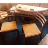 A 20th Century Dux teak oval extending dining table, raised on tapered legs; two similar dining