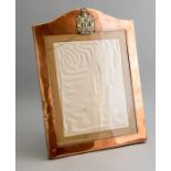 An Edwardian copper framed easel photo frame, arched top, with Scottish Kings Borders badge, opening