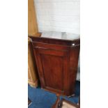 A George III oak wall hanging corner cupboard, circa 1820, moulded cornice above a single panel