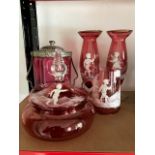 Five pieces of Mary Gregory style cranberry glass with enamelled children in landscapes including,