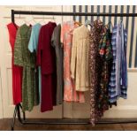 A collection of dresses, floral satin suits in various colours and styles 1950s/60s/70s. A 1960s