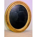 A Victorian and later giltwood and gesso oval wall mirror, moulded frame with foliate carving.