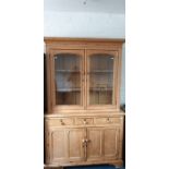 A Victorian pine bookcase on chest, circa 1870, moulded cornice above a pair of glazed doors