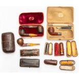 An assembled group of vintage smoking accessories, including three crocodile pipe cases (two with