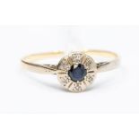 A sapphire and diamond 18ct gold cluster ring, set with a round cut sapphire (stone abraded),