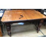 A Victorian mahogany extending dining table, fitted with two removable leaves, raised on heavy