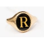 A 9ct gold and onyx signet ring, the oval onyx inset with a gold initial 'R', width approx. 13mm,